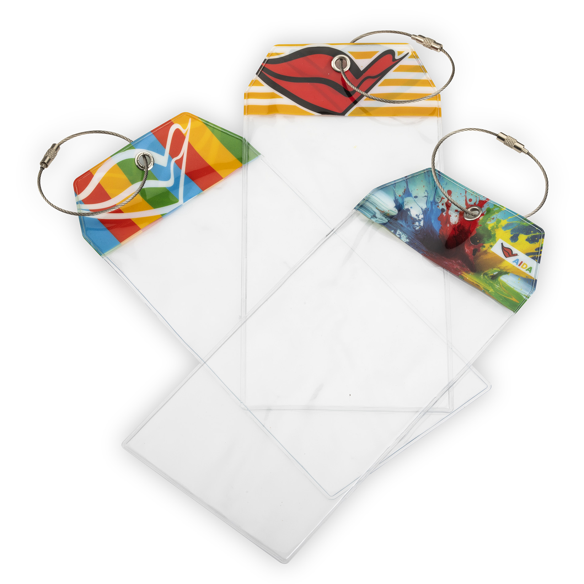 Drei transparente PVC-Kofferanhänger mit Metallösen und verschraubbarem Stahlband, jeweils mit AIDA Kussmund-Motiv auf weißem Hintergrund.